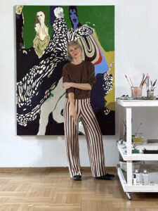 Maria Kozak in front of her oil painting in her studio