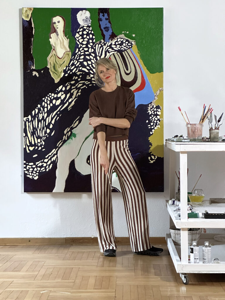 Maria Kozak in front of her oil painting in her studio